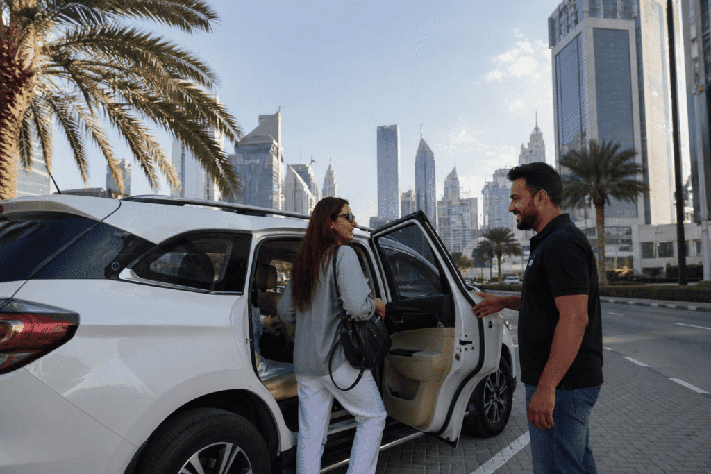 Passenger getting into a clean SUV car lift in Dubai with driver assistance, set against a modern city skyline, representing reliable daily transport services.